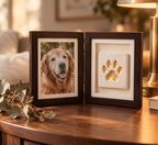 Finished double frame with a dog photo and gold-painted clay paw print on a side table